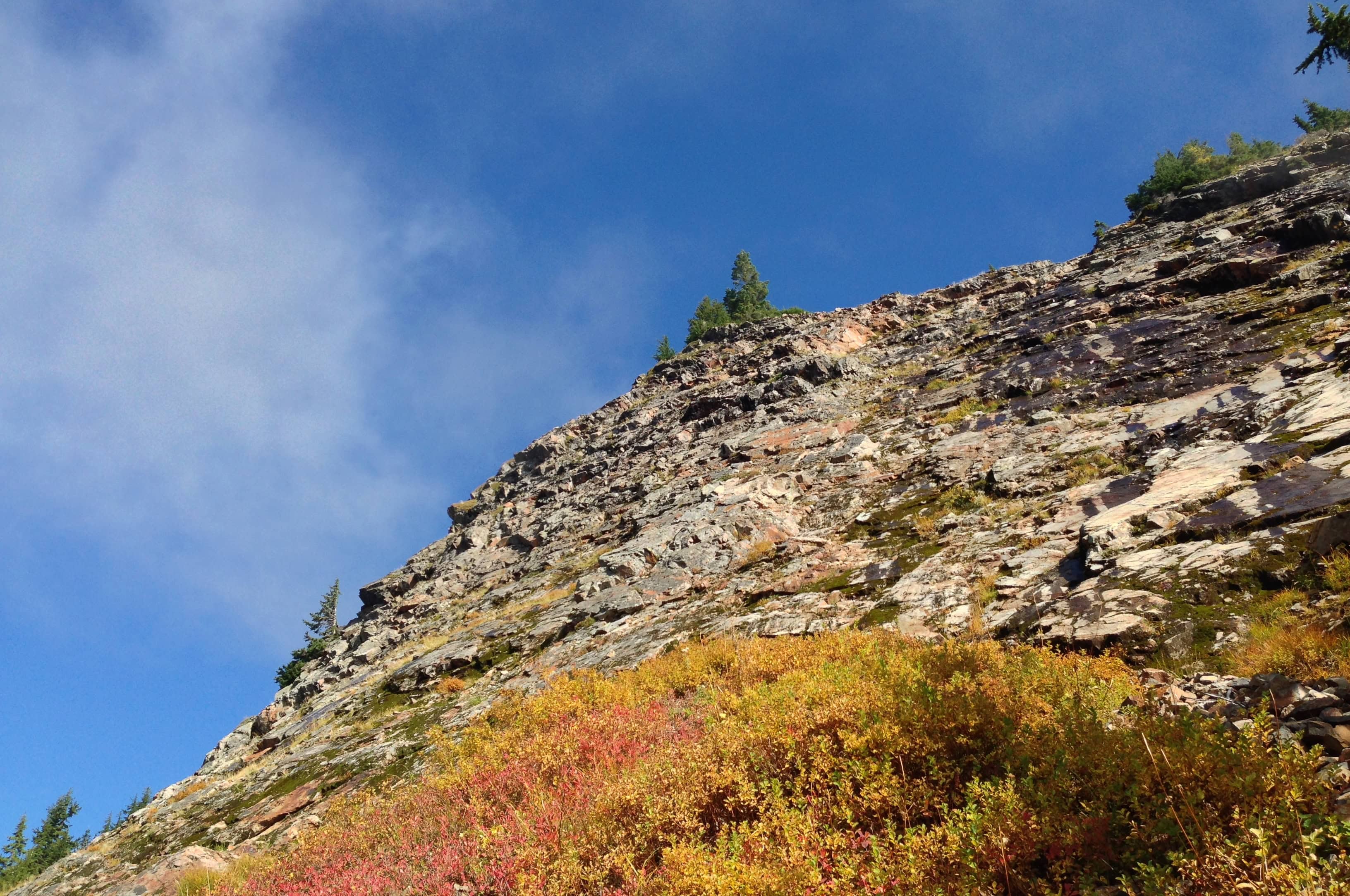Beyond Red Pond, the trail skirts the summit of Red Mountain. Hikers are warned not to venture off the trail up the mountainside, given its steep grade and flaky, unstable stone. In winter, the pass presents significant avalanche hazard. Commonwealth Basin – Red Pass Trail, October 19, 2014.